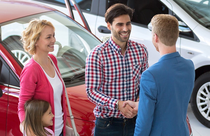 Customers shaking hands with the sales manager after buying a vehicles from Criswell GMC Gaithersburg