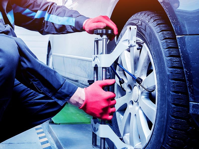 Mechanic performing a wheel alignment at Criswell GMC Gaithersburg dealership